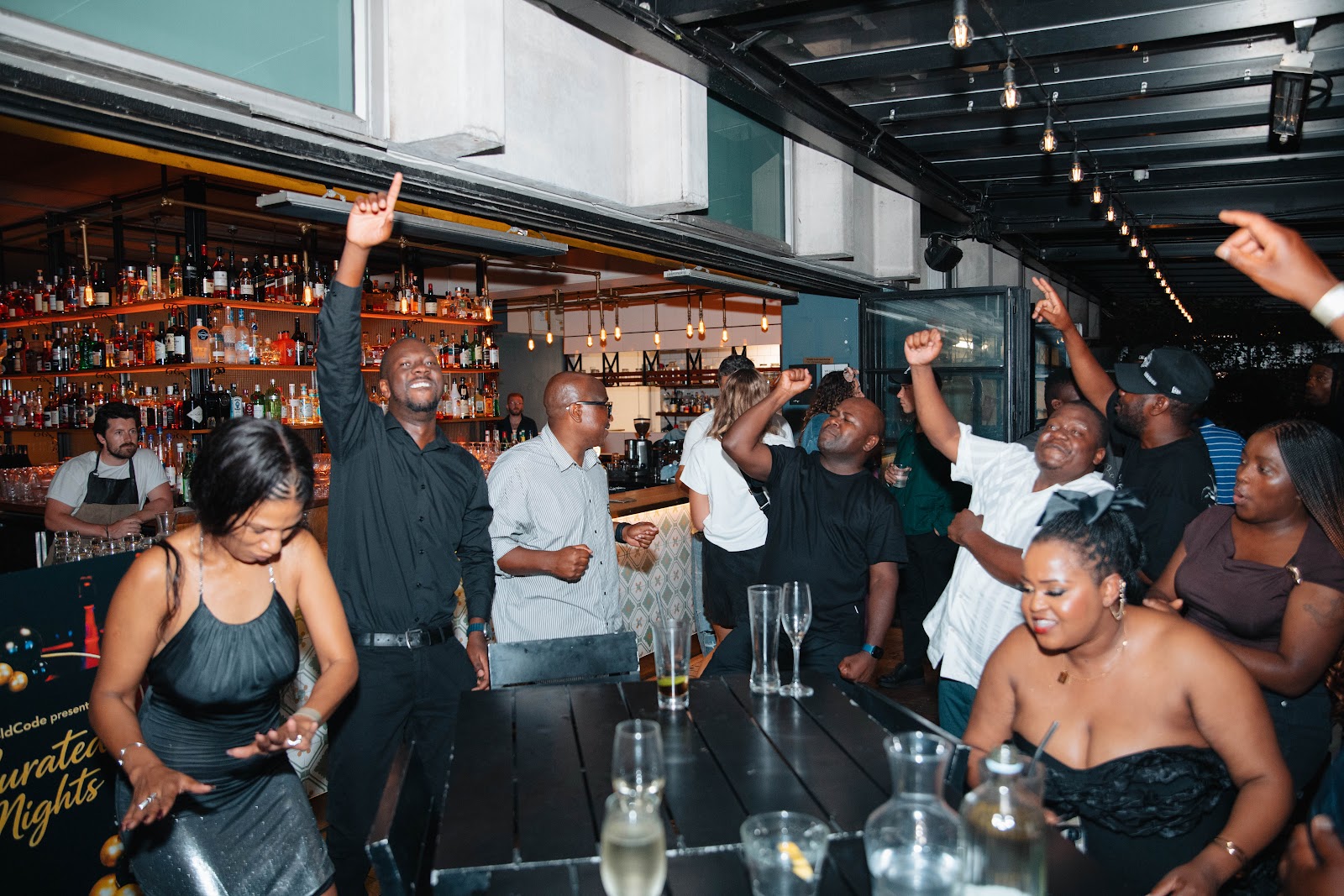 Guests with their hands in the air at a GoldCode Curated Nights party